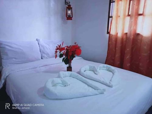 two towels in the shape of hearts on a bed at Reel Place in Kayagan