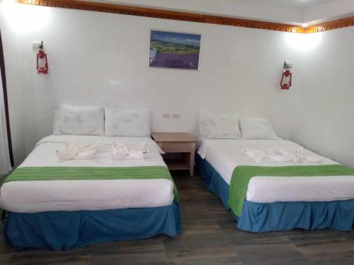 two beds in a hotel room with towels on them at Reel Place in Kayagan