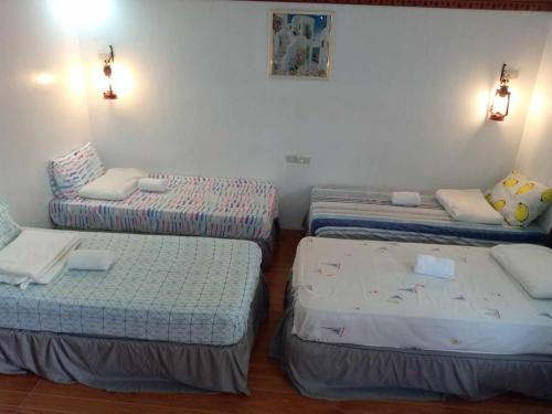 a room with three beds in a room at Reel Place in Kayagan