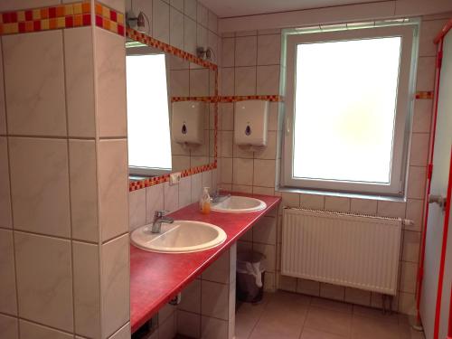 a bathroom with two sinks and two windows at Feriencamp Trassenheide in Trassenheide