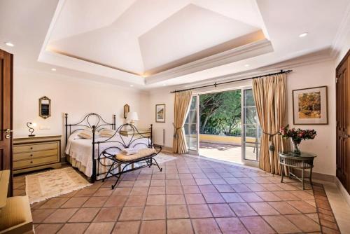 una camera da letto con un letto e una grande finestra di Villa Plaza - beautiful spacious house off roundabout 6 Quinta Do Lago a Quinta do Lago