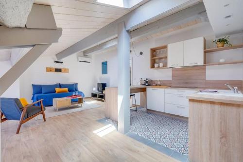 Il comprend une cuisine et un salon doté d'un canapé bleu. dans l'établissement Le Cosy, superbe appartement dans Saint Emilion, à Saint-Émilion