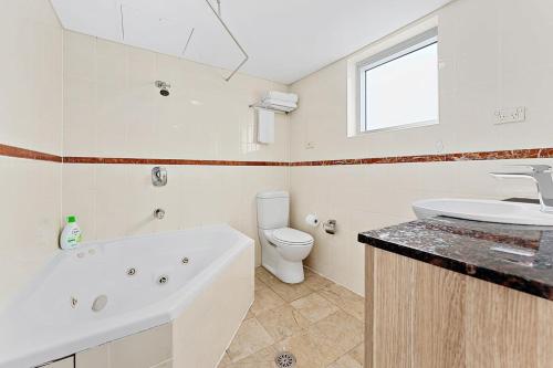 a bathroom with a tub and a toilet and a sink at AirCabin - Sydney CBD - Best Location -1 Bed Apt in Sydney