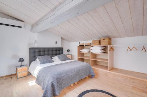 - une chambre avec un grand lit et du parquet dans l'établissement Le Cosy, superbe appartement dans Saint Emilion, à Saint-Émilion