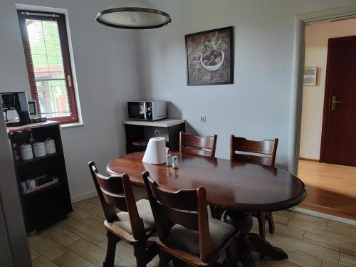 a dining room with a wooden table and chairs at Lwi dworek LD in Jarosław