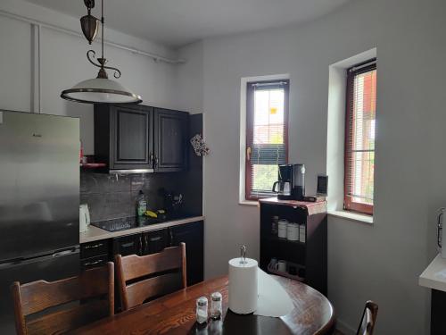 a kitchen with a wooden table and a refrigerator at Lwi dworek LD in Jarosław
