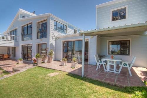 a house with a patio with a table and chairs at The Lookout Guest House in Port Alfred