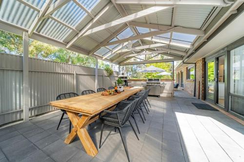 an outdoor patio with a wooden table and chairs at The Grape Escape Location and style on Shiraz Trail in McLaren Vale