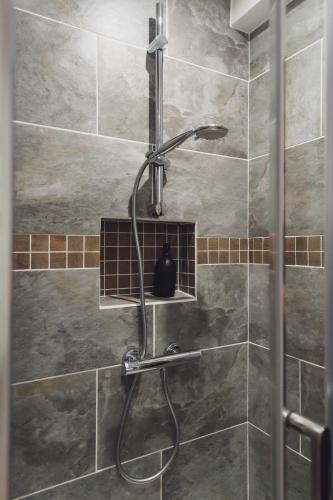 une douche avec pommeau de douche dans une salle de bain dans l'établissement 70 Cour La Fontaine, à Châtel-Saint-Germain