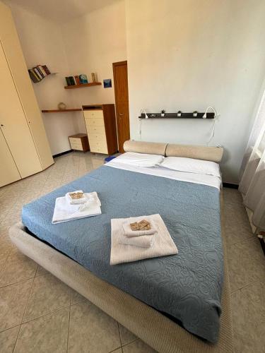 a room with a bed with two towels on it at Glitter Home in La Spezia