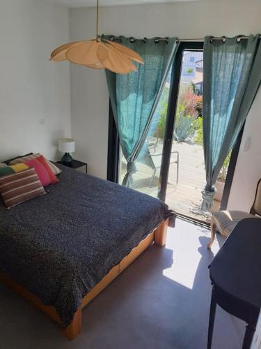une chambre avec un lit et une porte coulissante en verre dans l'établissement MAISON CONTEMPORAINE à 5KM DE BIARRITZ AVEC JACUZZI, à Bassussarry