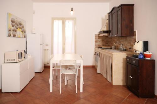 cocina con mesa y nevera blanca en Appartamento Rebecca en Palermo