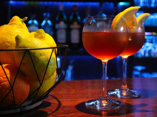 two glasses of wine and a bowl of fruit on a table at Casal dos Frades in Fontainhas