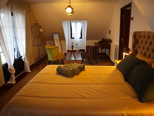 a bedroom with a large bed and a living room at Casal dos Frades in Fontainhas