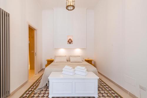 a white bedroom with a bed and a table at Casa Mea in Nardò