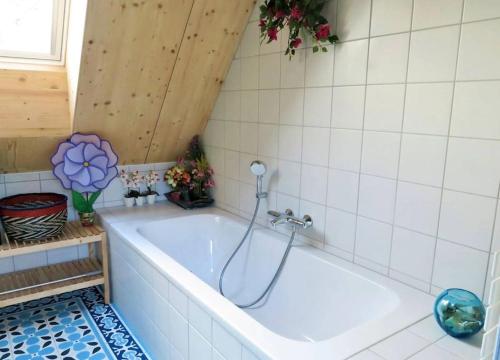 uma banheira com chuveiro na casa de banho em Gwez-Roz - Villa en bois Perros-Guirec em Perros-Guirec