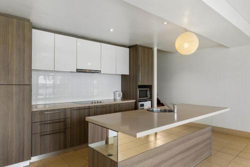 a kitchen with white cabinets and a counter top at Iririki Island Resort & Spa in Port Vila