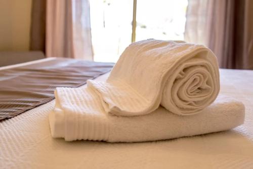 uma toalha enrolada em cima de uma cama em Marina Jardim - Great complex for families em Albufeira