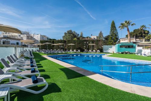 una piscina con tumbonas y un complejo en THB Maria Isabel - Adults Only, en Playa de Palma