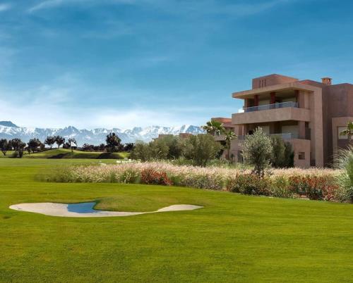 a view of a golf course with a building at Luxurious appartement in Marrakech with Pool&Golf PRESTIGIA AMBRE in Marrakesh