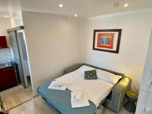 a small room with a bed and a painting on the wall at STUDIO VERT FSHH in Nice