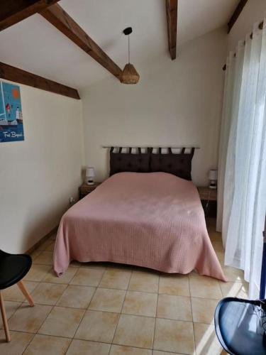 - une chambre avec un lit recouvert d'une couverture rose dans l'établissement L'hibiscus maison 4 personnes, à Dolus-d'Oléron