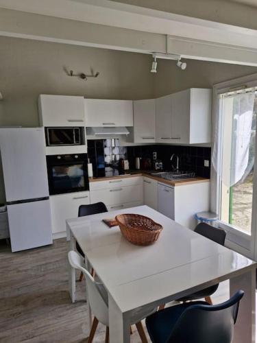 une cuisine avec une table avec un bol dessus dans l'établissement L'hibiscus maison 4 personnes, à Dolus-d'Oléron