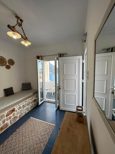 a room with a door and a couch and a mirror at Elenis Studios&Apartments in Masouri