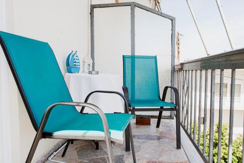 two blue chairs sitting on a balcony at Mavromati Rooms in Kivérion