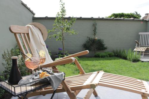 a rocking chair with a glass of wine in a yard at D’oude Dune in Nieuwpoort