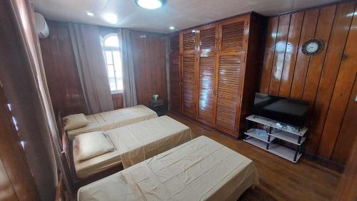 um pequeno quarto com 2 camas e uma televisão em Topaz Bed & Breakfast Hotel em San José