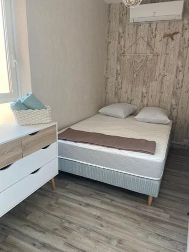 1 Schlafzimmer mit 2 Betten und einer Holzwand in der Unterkunft Mignon studio au cœur de Mèze in Mèze