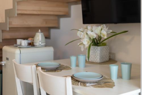a dining room table with blue plates and a vase of flowers at Le Casette di Giò in Monteodorisio
