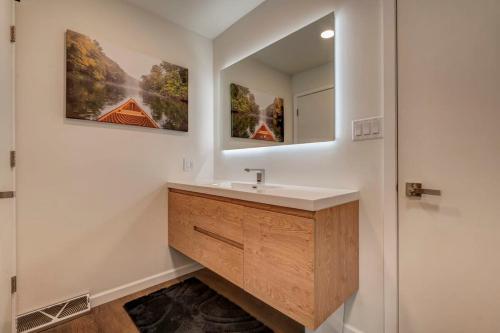 uma casa de banho com um lavatório e um espelho em Lakefront Retreat~Hot Tub~Game Room~Fire Pit~ BBQ em Spirit Lake