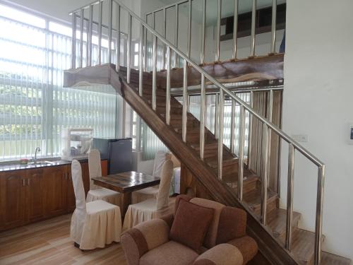 a living room with a staircase and a table and chairs at bucana traveler's inn in Guinisiliban
