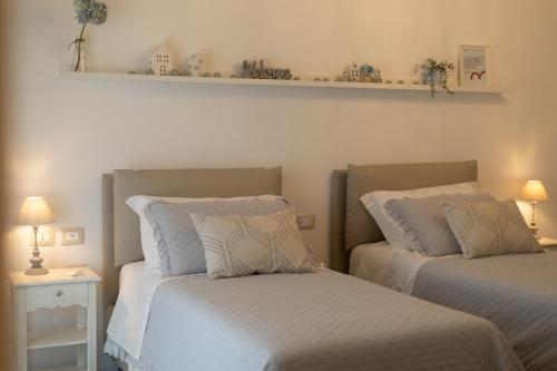 a bedroom with two beds and a shelf on the wall at Le Casette di Giò in Monteodorisio