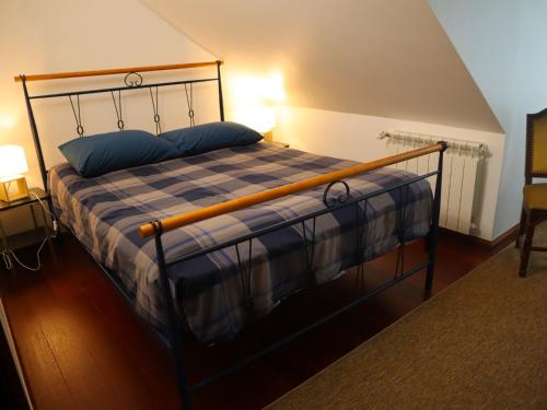 a bedroom with a bed with a metal frame and blue pillows at Casal dos Frades in Fontainhas