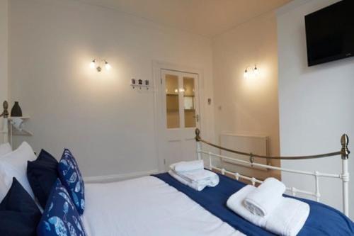 Un dormitorio con una cama y un televisor en la pared. en Crescent View - Panoramic sea views, en Filey
