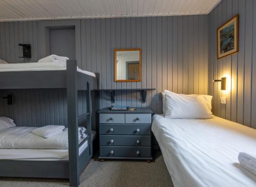 a bedroom with two bunk beds and a dresser at Insh Hall in Kincraig