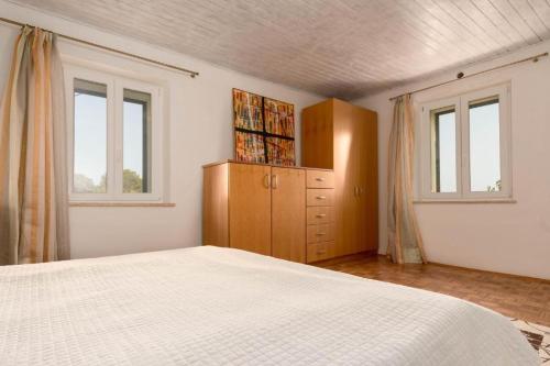 Schlafzimmer mit einem Bett, einem Schrank und Fenstern in der Unterkunft Stancia Rosa - Apartment sea view in Poreč