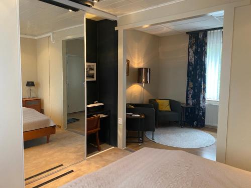 a bedroom with a mirror and a bed and a couch at De Post B&B Restaurant in Klimmen