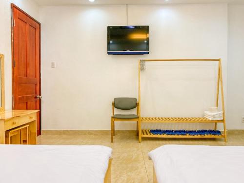 a room with two beds and a tv on the wall at HẢI ANH in Da Lat