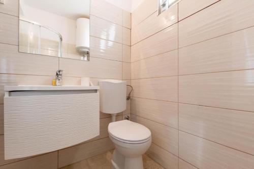 Stancia Rosa - Apartment sea view في بوريتش: حمام به مرحاض أبيض ومغسلة