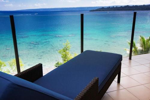 a table on a balcony with a view of the ocean at Iririki Island Resort & Spa in Port Vila