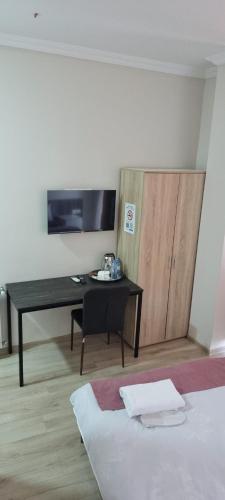 a bedroom with a desk and a bed and a table at MAHALI HOTEL in Batumi