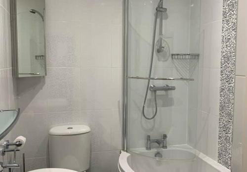 Un baño con ducha, inodoro y lavabo. en Apartment 5, 11 The Beach - Spectacular views of the bay, en Filey