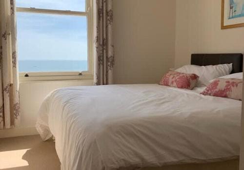 Una cama blanca en una habitación con ventana. en Apartment 5, 11 The Beach - Spectacular views of the bay, en Filey
