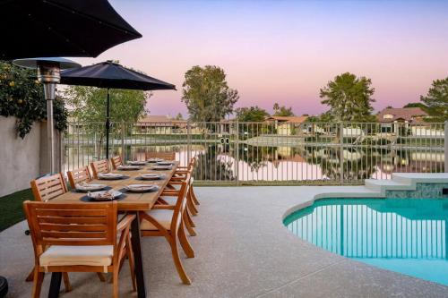 a table with chairs and an umbrella next to a pool at Lakeside Views The Clubhouse at Arrowhead Pool in Glendale