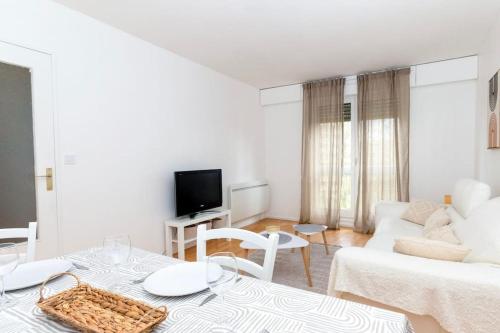 un salon blanc avec un canapé blanc et une télévision dans l'établissement Le p'tit Lorry, à Metz