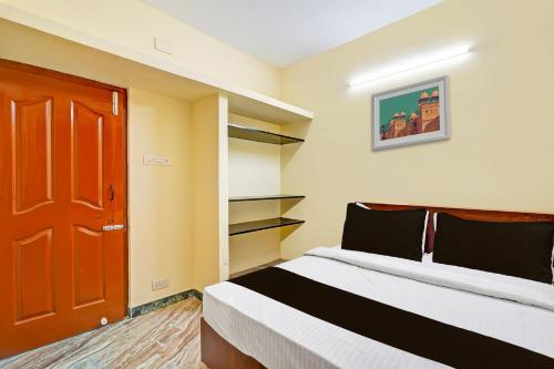 a bedroom with a bed and a red door at OYO Nimalan INN in Chennai